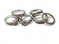 Photo of multiple silver tone Swarovski rings with solitaire and pave crystal settings showing condition and imperfections.