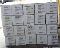 Photo showing full lot of 20 stacked white rectangular boxes labeled CE413A HP 305A magenta toner cartridges by NuPrint.