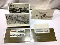 Four Canadian locomotive stamps mounted on display card with historical train photo and map sheets in the background.