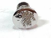 Close-up of the round silver tone lapel pin showing the detailed lion's head with clear crystals forming the mane, with reflective finish.