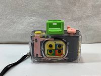 Front view of the transparent Lomography Action Sampler camera with colorful lens array and colored controls on top