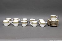 Full set of 11 Royal Doulton 'Sonnet' bone china teacups and saucers arranged in a row with saucers stacked on the right and one teacup on a saucer.