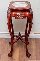 Full front view of plant stand showing carved openwork panels, cabriole legs and marble top