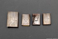 Four antique sterling silver matchbox holders aligned horizontally showing front faces and monograms