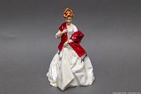 Front view of the Royal Worcester porcelain figurine showing the woman in a white dress and red shawl
