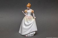 Front view of Royal Doulton porcelain figurine 'Gift of Love' HN-3427 showing the young woman in white dress holding skirt.