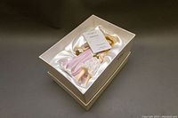 Porcelain figurine seated in original box with satin lining, includes certificate on top