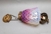 Full view of antique pendant light with frosted glass shade and brass hanging hardware showcasing the color gradient and floral etchings.