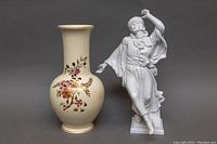 Front angled view of the Herend porcelain figurine and Zsolnay hand painted vase together