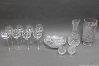 Photo showing the full set: 8 wine glasses, 2 vases, a bowl, salt and pepper shakers, and Stuart crystal pitcher on grey background.