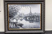 Full front photo of framed oil painting showing Paris river, bridges, Eiffel Tower, boats, and cityscape in black and white.