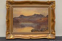 Front view of framed landscape painting in ornate gilt frame