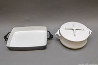 Front view of 10.75 inch rectangular pan and covered pot with lid on, both white enamel interior and exterior black and white respectively.