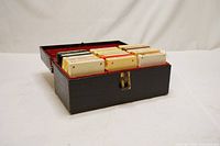 Black carrying case open showing 15 assorted 8-track tapes organized inside.
