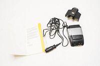 Radar detector with power cord, mounting bracket, and manual displayed on white background.