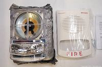 Close-up photo of the Simplex fire alarm appliance components including the horn and white cover labeled 'FIRE'.