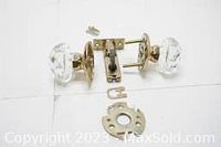 Front and side view of faceted clear glass door knob with brass base and locking mechanism.