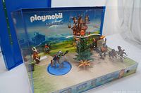 Front view of the Playmobil Knights display box showing mounted knights, horses, a tree, and other medieval scene elements.