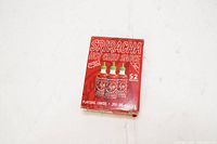 Front view of the unopened box of Sriracha Hot Chili Sauce Playing Cards showing three bottles on red background with text about 52 recipes.