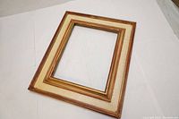 Front view of vintage wooden picture frame showing pastina finish and gold-brown detailing.