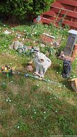 Plaster white owl, black plastic owl, small metal bicycle, fawn figure, wooden birdhouse and assorted stakes on lawn