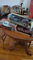 Photo showing boxed Motor Max model cars on wooden table, including the 1:24 die cast trailer pack of 1956 Ford pickup with 1932 Ford coupe, and other boxes below