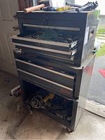 Overall view of stacked top and bottom steel tool chests with drawers open and tools visible