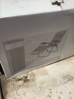 Box with image and description of the Cosmopolitan Zero Gravity Chair, showing reclining lawn chair image.