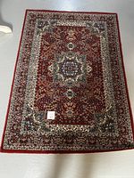 Full view of the Persian style wool rug showing central medallion and border patterns.