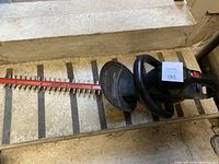 Photo showing the full electric hedge trimmer with 20-inch blade, black body, and protective guard.