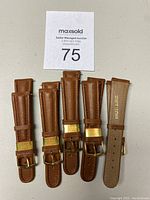 Five new brown leather watch straps arranged side by side, showing gold-tone buckles and leather loops, each stamped with 'RIOS1931' and '20mm' marking visible on the underside of one strap.