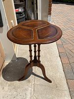 Full view of the antique small side table showing leather top with three divided sections and tripod wooden base.