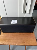 Front view of Pioneer center channel speaker with fabric grill on a wooden table.