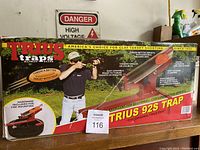 Photo of the original packaging box for the Trius 92S clay target shooting machine with branding and usage details.