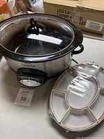Rival Crock-Pot slow cooker with glass lid and sectioned serving tray on table