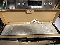 Photo of the Party Hostess Warm-O-Tray food warmer showing three circular warming coils and connected electric cord inside the original box.