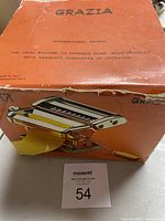Orange Grazia branded box showing a photo of the pasta maker machine with dough sheet