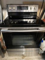 Front view of Samsung electric range showing glass cooktop, oven door with window, and stainless steel finish