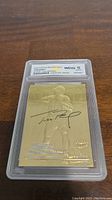 Front of 2000 Fleer Ultra 23kt Gold Tom Brady rookie card with autograph, graded WCG 10 Gem-Mint.