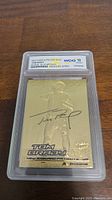 Front view of 2000 Fleer Ultra 23kt Gold Tom Brady Rookie Card in blue metallic, graded WCG 10 encapsulated.