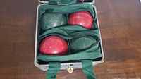Full view of the bocce ball set inside the open carrying case with 4 red and 4 green balls
