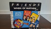 Front of the Friends Wheel of Mayhem game box showing title and characters