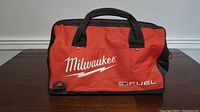 Front view of Milwaukee Fuel branded tool bag showing handle and logo.
