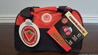 Photo showing front of the black and red carry bag with Canadian Tire Roadside Assistance logos and labels