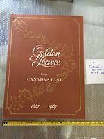 Front cover of the large hardcover book titled 'Golden Leaves from Canada's Past 1867-1967' showing gold embossed maple leaf design and title text.
