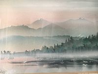 Close-up of the watercolor painting showing mountain landscape with mist and trees.