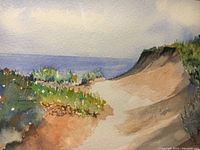 Close up of the watercolor painting showing coastal dunes and ocean under cloudy sky.