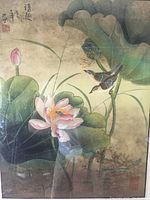 Close-up of framed artwork showing detailed lotus flowers, leaves, two small birds, calligraphy, and red seals