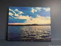 Front view showing the lake and sky photo printed on stretched canvas with vibrant colors.
