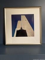 Framed color photo of Twin Towers with silver frame and white mat showing sky and building details